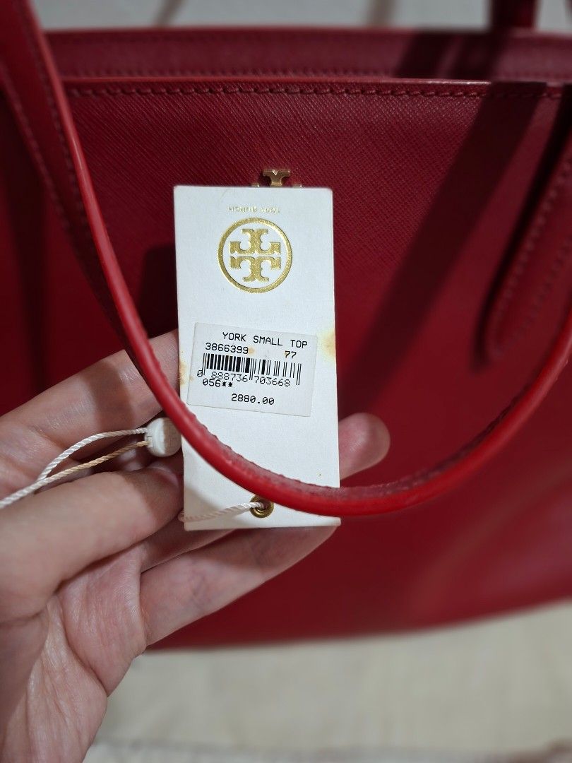 Tory Burch York Small Top Tote Bag Red (Category: Tote Bags) located in Baliuag. Submitted by prettylychee_24 (Listing ID 1471135518, Image 3). Description: - Brand: Tory Burch - Style: York Small Top Tote - Material: Premium Saffiano leather in vibrant red - Hardware: Gold-tone with minimalist front logo emblem - Straps: Double adjustable shoulder straps - Condition: Brand new with original store tag attached (Model: 3866399, Price: $2,880) - In