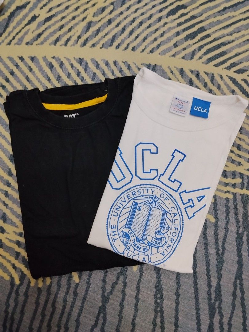 UCLA and CAT T-shirt bundle set (Category: Shirts) located in Manila. Submitted by titokingcuratedarchive (Listing ID 1471146726, Image 1). Description: - Bundle of 2 crewneck t-shirts: 1 White UCLA graphic tee and 1 Black tee with CAT branding - Made from breathable cotton fabric with standard short sleeve cut - Easy to pair with your favorite jeans or shorts - Ideal for casual, everyday wear - Great value bundle deal.