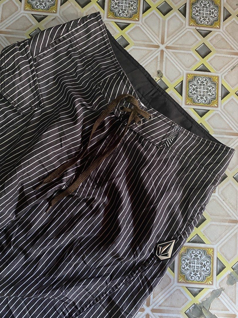Volcom Pinstripe Board Shorts Size 30 (Category: Swim Trunks & Board Shorts) located in Carcar. Submitted by eroncarvaj68638 (Listing ID 1471170984, Image 3). Description: - Brand: Volcom - Style: Board shorts in black and white pinstripe pattern - Size: 30 (marked on tag) - Material: 100% polyester - Features: Drawstring waist, side cargo pocket on right leg, and signature Volcom stone rubber patch - Details: Stylish angled stripes on the back y