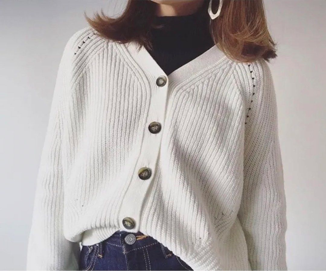 White Knitted V-Neck Cardigan (Category: Coats, Jackets and Outerwear) located in Cavite. Submitted by yakultjeni85475 (Listing ID 1471285200, Image 1). Description: - Color: White - Style: Oversized cardigan with V-neckline and dark front buttons - Material & Texture: Chunky knit fabric with ribbed cuffs and hem - Design: Modern high-low hemline - Fit: Comfortable and versatile - Best for: Layering over basic tops or turtlenecks during cooler we