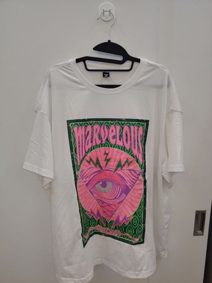 White T-Shirt with Marvelous Graphic Print (Category: Shirts) located in Manila. Submitted by babeboxtheory (Listing ID 1471171756, Image 1). Description: - Style: Casual short-sleeve t-shirt with a relaxed fit and classic crew neck - Design: Eye-catching 'MARVELOUS' front print in pink over a psychedelic eye and lightning bolt graphic - Color: Crisp white base with a vibrant green patterned background.