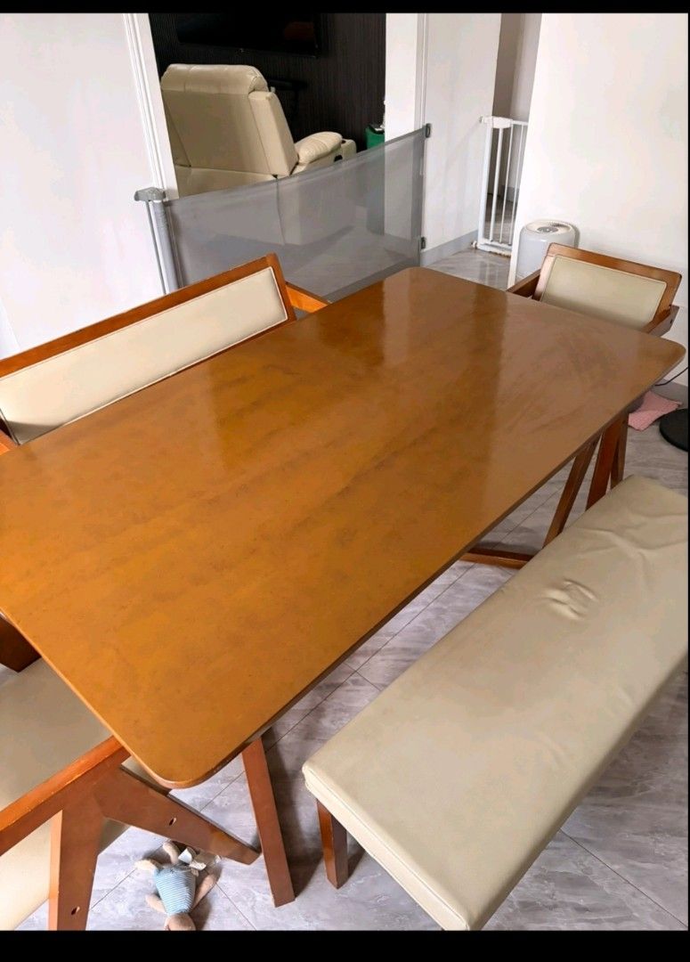 Wooden dining table set with chairs and bench (Category: Tables & Sets) located in Pasay City. Submitted by enajm (Listing ID 1471203569, Image 1). Description: - Wooden dining table set with matching bench and chairs - Warm brown tabletop with sturdy wooden frames and stylish angled legs - Cream faux leather cushions on all seats (Note: one cushion has a noticeable indentation mark) - Perfect size for cozy family meals and gatherings - Self-coll