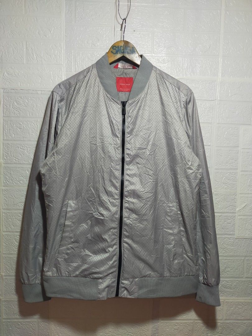 Zara Man Grey Bomber Jacket Size XL (Category: Coats, Jackets and Outerwear) located in Valencia. Submitted by cabisaythriftshop (Listing ID 1471222724, Image 1). Description: - Brand: Zara Man - Size: XL - Color: Grey - Closure: Full zip front - Details: Ribbed collar, cuffs, and hem - Design: Micro-perforated front panels with solid sleeves and back - Style: Lightweight casual layer.