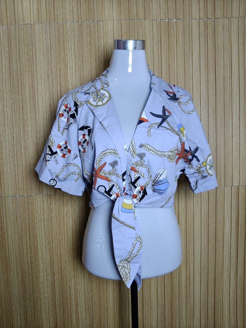 Zara Nautical Print Tie-Front Crop Top (Category: Blouses) located in Taguig. Submitted by ashie_clothing (Listing ID 1471256973, Image 2). Description: - Brand: Zara - Condition: Brand new with original tags attached (unworn) - Color/Design: Light blue with marine print (ropes, anchors, starfish) - Features: Short sleeves, lapel collar, front tie detail - Closure: Hidden side zipper - Style: Crop top.
