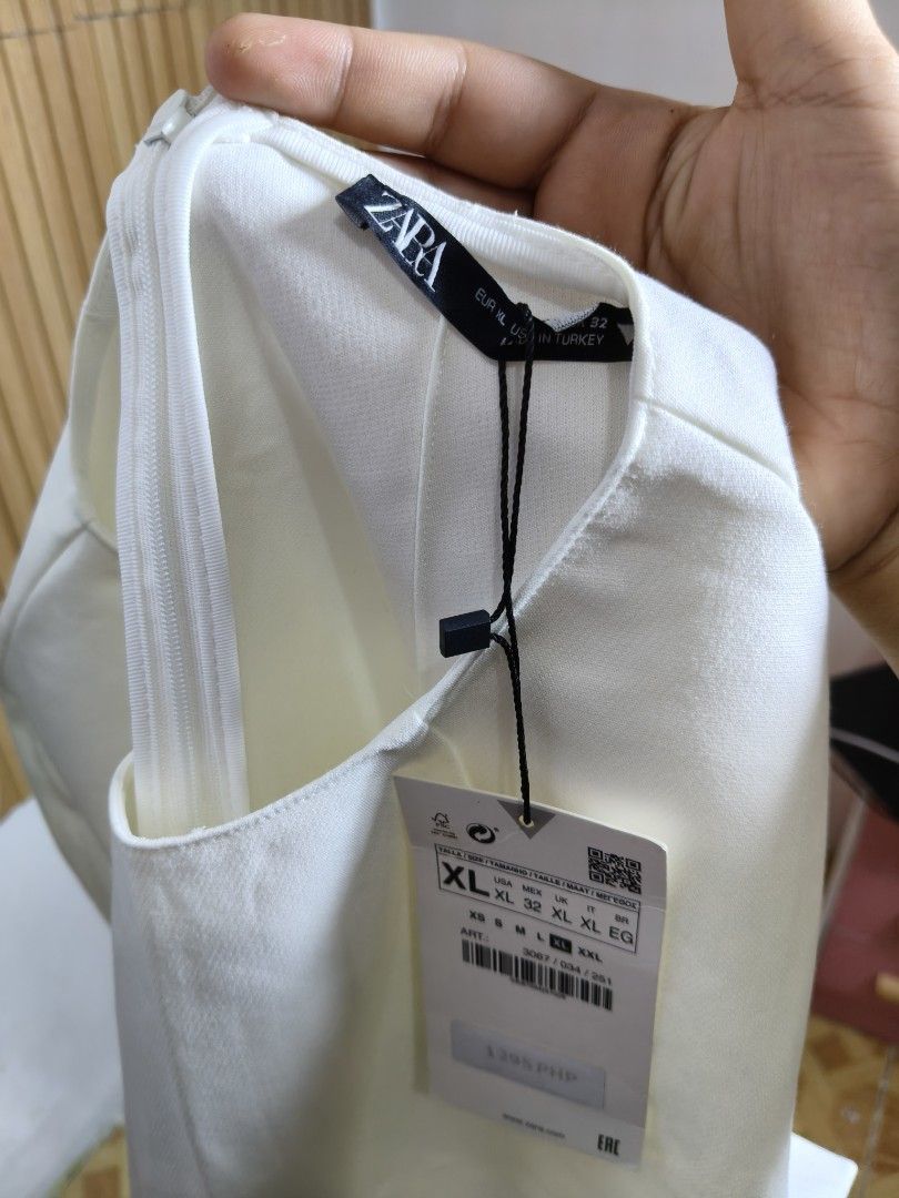 Zara White Short Sleeve Crop Top (Category: Blouses) located in Taguig. Submitted by ashie_clothing (Listing ID 1471256780, Image 3). Description: - Brand: Zara - Style: Crop top with short sleeves and round neckline - Size: XL - Condition: Brand new with original store tags attached - Details: Clean solid white color, concealed back zip closure - Fit: Great basic piece, perfect for pairing with high-waisted bottoms.