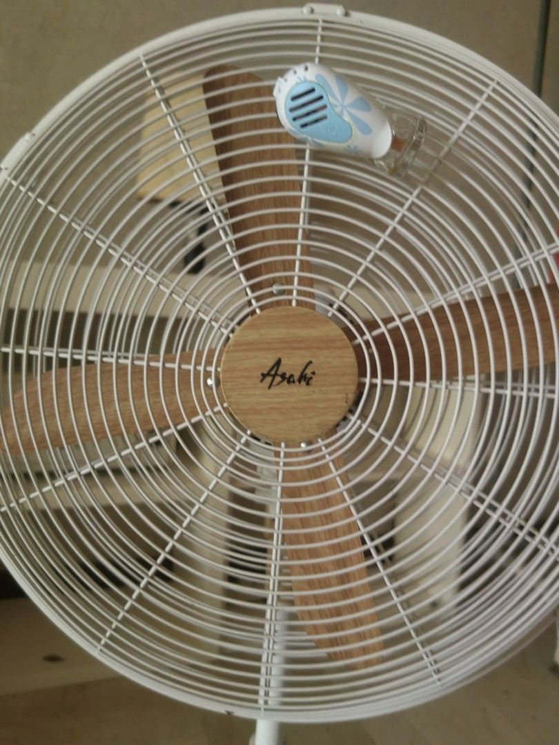 Asahi Wooden Blade Standing Fan (Category: Fans) located in Makati City. Submitted by donald1983 (Listing ID 1471307954, Image 3). Description: - Color: White with chic wood-look blades and pole - Condition: Fully working, blows strong air - Features: Adjustable height, oscillation, and multiple speed settings - Safety: Secure wire safety cage and sturdy round base - Ideal for: Living rooms and bedrooms.