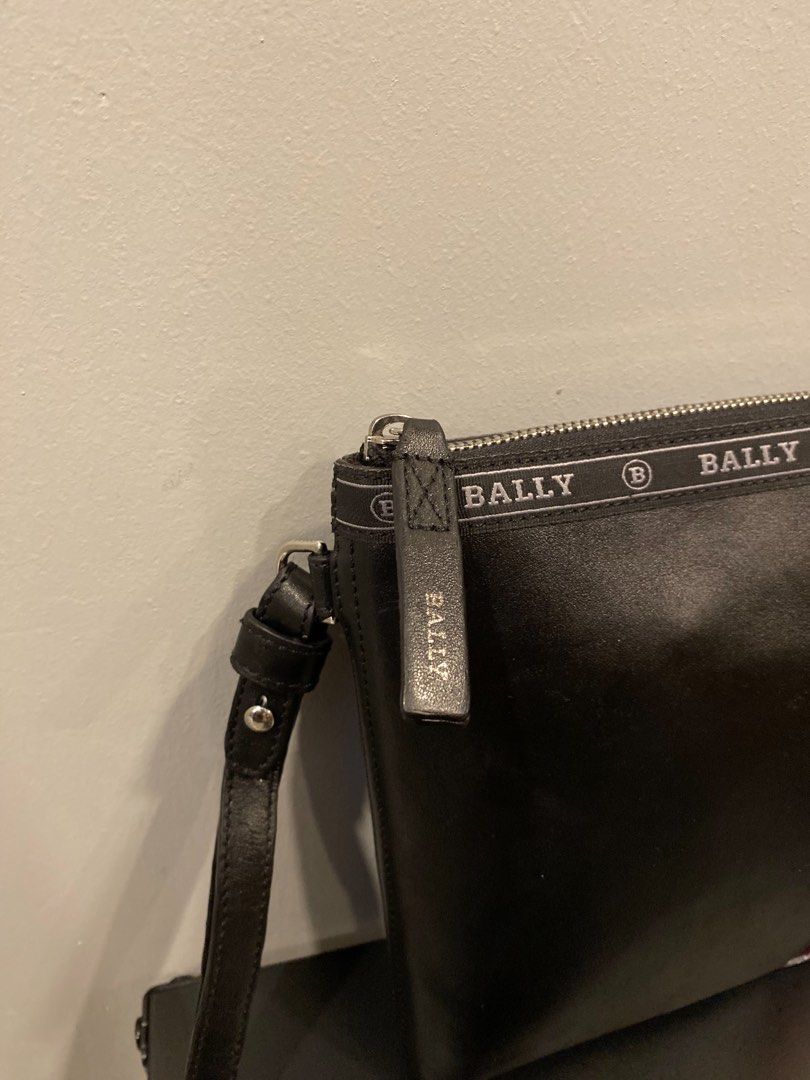 Bally GYSE Leather Clutch Bag (Category: Clutches) located in San Isidro, Davao del Norte. Submitted by nikkody226_488 (Listing ID 1471436236, Image 3). Description: BALLY HARTLAND LEATHER CLUTCH – BLACK / RED STRIPE Crafted from genuine micro-grain leather, featuring Bally’s signature red and cream stripe detailing and branded trim along the zipper. Comes with a convenient leather wrist strap and a spacious main zippered compartment for organizi