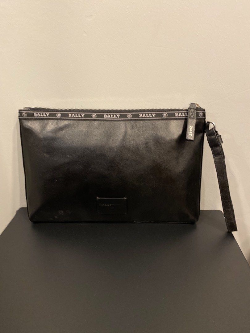 Bally GYSE Leather Clutch Bag (Category: Clutches) located in San Isidro, Davao del Norte. Submitted by nikkody226_488 (Listing ID 1471436236, Image 2). Description: BALLY HARTLAND LEATHER CLUTCH – BLACK / RED STRIPE Crafted from genuine micro-grain leather, featuring Bally’s signature red and cream stripe detailing and branded trim along the zipper. Comes with a convenient leather wrist strap and a spacious main zippered compartment for organizi