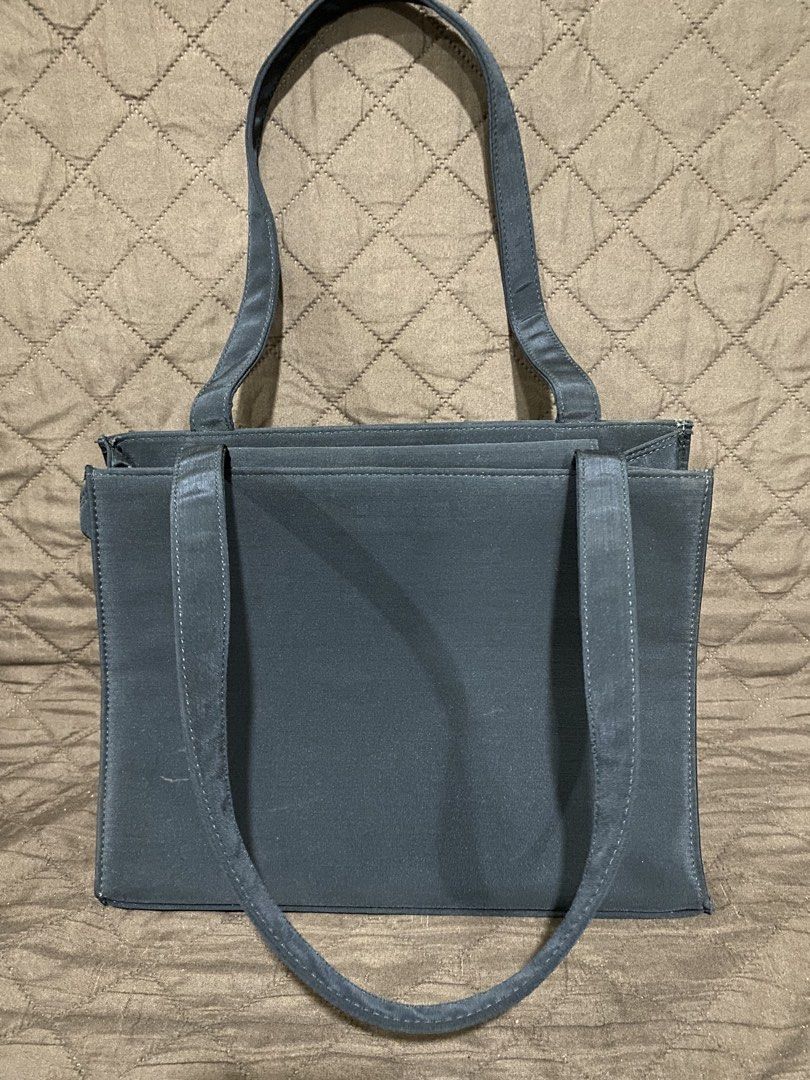 Black Fabric Tote Bag with Shoulder Straps (Category: Tote Bags) located in Manila. Submitted by divinemercy_29 (Listing ID 1471309830, Image 1). Description: - Color: Black - Material: Durable fabric with structured shape that stays upright - Closure: Snap button on middle section - Pockets: Multiple interior compartments, 1 interior zip pocket, and 1 exterior back zip pocket - Straps: Dual secure shoulder straps - Condition: Clean exterior with