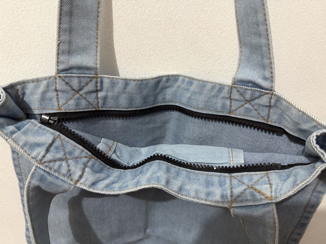 Denim Tote Bag (Category: Tote Bags) located in Pasig City. Submitted by yoroshikuonegaishimasu (Listing ID 1471391279, Image 3). Description: Light wash denim tote bag Zipper closure but missing puller (jacket type) Open slip pocket Size: Height: 15.5 in Length: 13 in Width: 1.5 in Payment first via GCash or Paymaya only No Meet-up/COD/COP/Rider Abono No return, exchange or refund Delivery: Grab or Lalamove J&T (during weekend only) Location: Pa