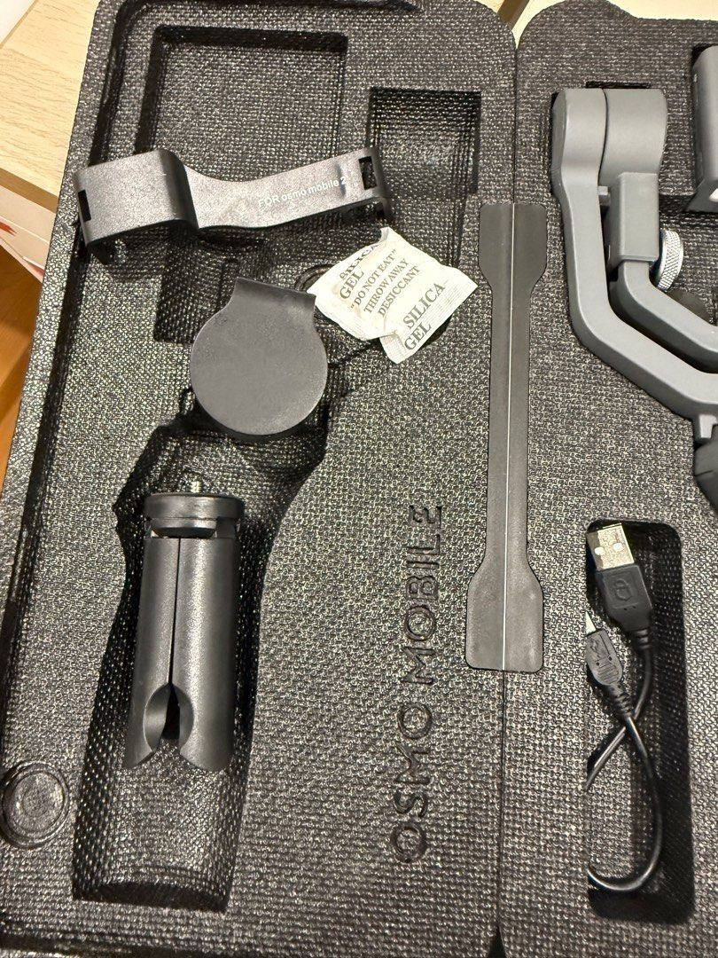 DJI Osmo Mobile 2 Smartphone Gimbal Stabilizer - Negotiable!!! (Category: Gimbals & Stabilizers ) located in Manila. Submitted by axelyuna.27 (Listing ID 1471332023, Image 2). Description: - Brand: DJI Osmo Mobile 2 Smartphone Gimbal Stabilizer - Condition: Excellent, clean grey finish - Included: Protective molded foam case with organized slots - Accessories: Charging cable, mini tripod stand, and accessory mount included - Features: Smooth stab
