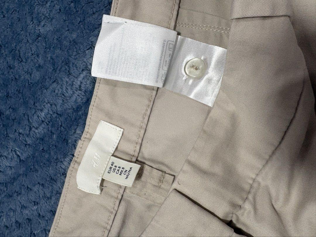 H&M Beige Cotton Cargo Pants (Category: Other Bottoms) located in Marilao. Submitted by luckystone_0cdaee (Listing ID 1471298076, Image 3). Description: H&M beige cotton cargo pants feature a classic utility design with signature oversized flap side pockets, a flat front waistband with hidden closures, and adjustable toggle drawstrings at the bottom cuffs for a customizable straight-leg or cinched look. Size: can fit 30-32 waist Length: 38".