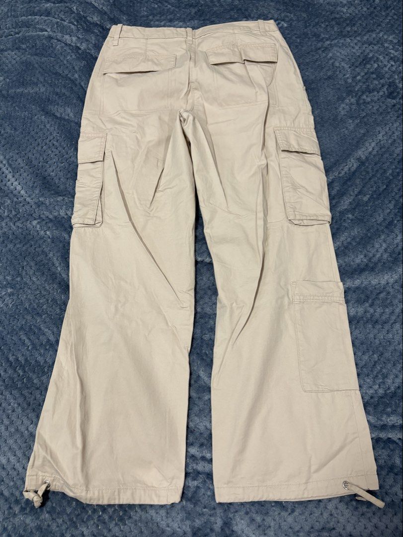 H&M Beige Cotton Cargo Pants (Category: Other Bottoms) located in Marilao. Submitted by luckystone_0cdaee (Listing ID 1471298076, Image 2). Description: H&M beige cotton cargo pants feature a classic utility design with signature oversized flap side pockets, a flat front waistband with hidden closures, and adjustable toggle drawstrings at the bottom cuffs for a customizable straight-leg or cinched look. Size: can fit 30-32 waist Length: 38".