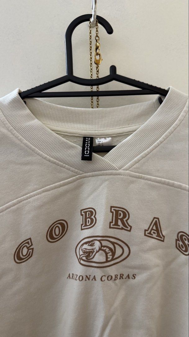 H&M Sweatshirt Size L (Category: Coats, Jackets and Outerwear) located in Makati City. Submitted by andrae.thomas (Listing ID 1471366932, Image 2). Description: - Brand: H&M Divided - Color: Cream with brown Arizona Cobras chest graphic - Size: L - Details: Ribbed v-insert at the neckline, dropped shoulders - Condition: Pre-loved with a tiny stain (please refer to the last photo for details) MAKATI AREA Meet Up: TAFT, Dlsu, CSB, Cash and Carry Fi