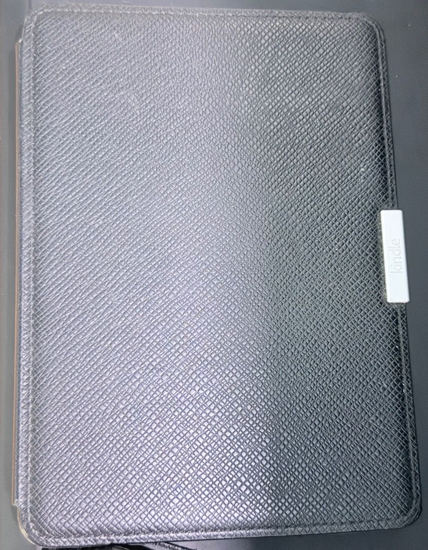 Kindle Paperwhite with case (6") (Category: E-Readers) located in Santa Rosa. Submitted by biancamarie0404 (Listing ID 1471340199, Image 3). Description: - Fully functional Amazon Kindle e-reader with a crisp touchscreen and clear e-ink text - Great battery life with a visible percentage indicator at the top right - Includes a textured black leather folio case with a secure magnetic closure tab - Adjustable font sizes and built-in store menus for