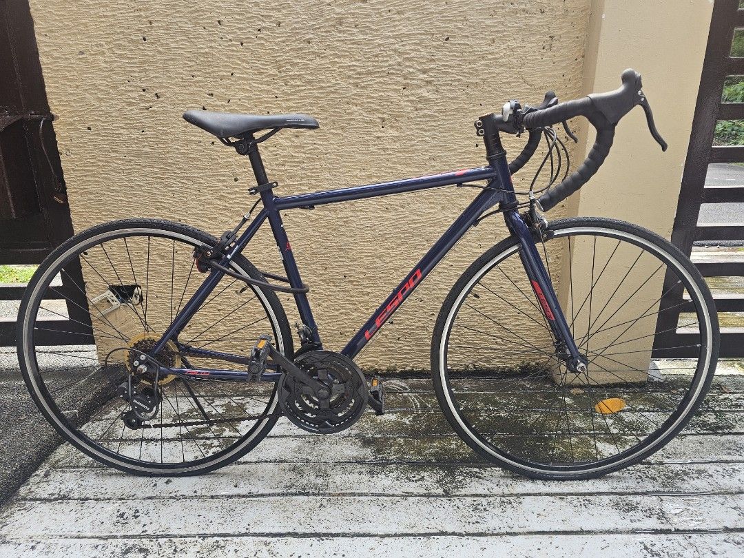 Lespo Road Bike Bicycle (Category: Bicycles) located in Paranaque City. Submitted by mfam1986 (Listing ID 1471399093, Image 2). Description: - Brand: Lespo road bike - Color: Dark blue with black saddle and wheels - Handlebars: Drop handlebars - Gearing: Shimano setup with standard multi-gear crankset - Safety: Reflectors fitted - Condition: Used with minor frame scuffs; rides fine and shifts smoothly - Best for: Daily commuting or weekend starte