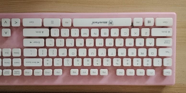 MicroPack Pink and White Mechanical Keyboard (Category: Computer Keyboard) located in Roxas City. Submitted by demalatagiboy (Listing ID 1471392146, Image 1). Description: - Brand: MicroPack - Design: Pink frame with white keycaps and full numpad (Standard QWERTY layout) - Connection: Wired - Condition: Fully functional, shows minor dust and marks around the keys from normal use - Ideal for: Typing, work, or gaming desk setups.
