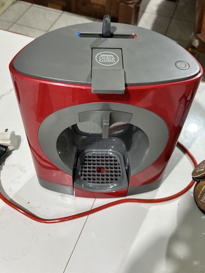 Nescafe Dolce Gusto Coffee Machine Bundle with Capsule Holder and Pods (Category: Coffee Machines & Makers) located in Manila. Submitted by beaaa.4 (Listing ID 1471429029, Image 3). Description: - Red and grey Nescafe Dolce Gusto capsule coffee machine - Includes a black revolving capsule stand - Comes with opened boxes of Flat White and Cafe Au Lait pods - Plugged in and ready to use - Great home coffee setup, selling as I'm clearing out kitchen
