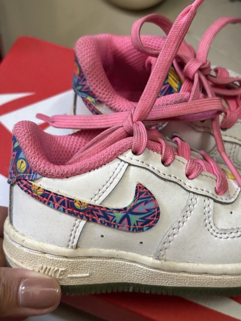 Nike Air Force 1 Toddler Size 4C (Category: Babies & Kids Fashion) located in Antipolo. Submitted by namiquinn (Listing ID 1471315214, Image 2). Description: - Brand: Nike Air Force 1 Toddler - Size: US 4C / UK 3.5 / EUR 19.5 - Style Code: FJ3487-100 - Color/Design: White leather upper, bright pink inner lining, pink laces, and colorful patterned swoosh with basketball graphics - Condition: Shows minor wear on soles and uppers from normal toddler