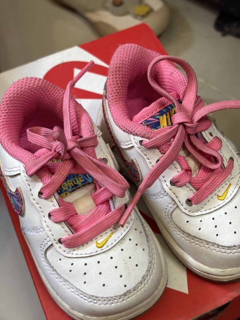 Nike Air Force 1 Toddler Size 4C (Category: Babies & Kids Fashion) located in Antipolo. Submitted by namiquinn (Listing ID 1471315214, Image 1). Description: - Brand: Nike Air Force 1 Toddler - Size: US 4C / UK 3.5 / EUR 19.5 - Style Code: FJ3487-100 - Color/Design: White leather upper, bright pink inner lining, pink laces, and colorful patterned swoosh with basketball graphics - Condition: Shows minor wear on soles and uppers from normal toddler