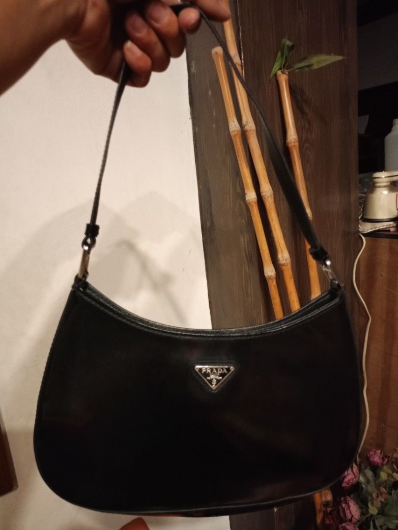 Prada Black Leather Shoulder Bag (Category: Luxury Bags & Wallets) located in Quezon City. Submitted by cher_jayanne (Listing ID 1471416646, Image 1). Description: - Brand: Prada - Style: Classic curved hobo shoulder bag - Material: Premium black leather - Hardware: Silver-tone with branded metal links - Closure: Secure snap closure - Interior: Clean lining, metal logo plaque, and tag numbered 175 - Condition: Excellent, clean inside and out - Au