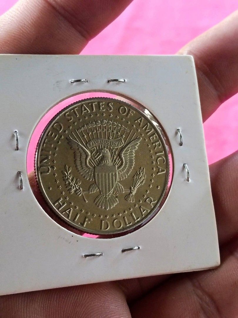 Proof 2005 US Kennedy Half Dollar Coin (Category: Currency) located in Batangas. Submitted by swiftstone.96924b (Listing ID 1471312359, Image 2). Description: - Item: US Kennedy proof Half Dollar Coin - Year & Mint Mark: 2005-S - Finish: Gold-toned - Condition: Encased in a protective cardboard coin flip holder with handwritten notes - Ideal for: Coin collectors and numismatists.