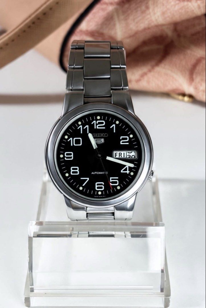Seiko 5 Automatic Watch Black Dial (Category: Men's Watches) located in Manila. Submitted by trishea.321 (Listing ID 1471360073, Image 1). Description: - Model: Seiko 5 Automatic Watch - Dial: Bold black dial with full Arabic numerals - Case & Bracelet: Stainless steel - Features: Day and date window at the 3 o'clock position - Details: Clear sweep second hand with a distinctive red tip - Condition: Reliable daily wearer with clean, classic styli