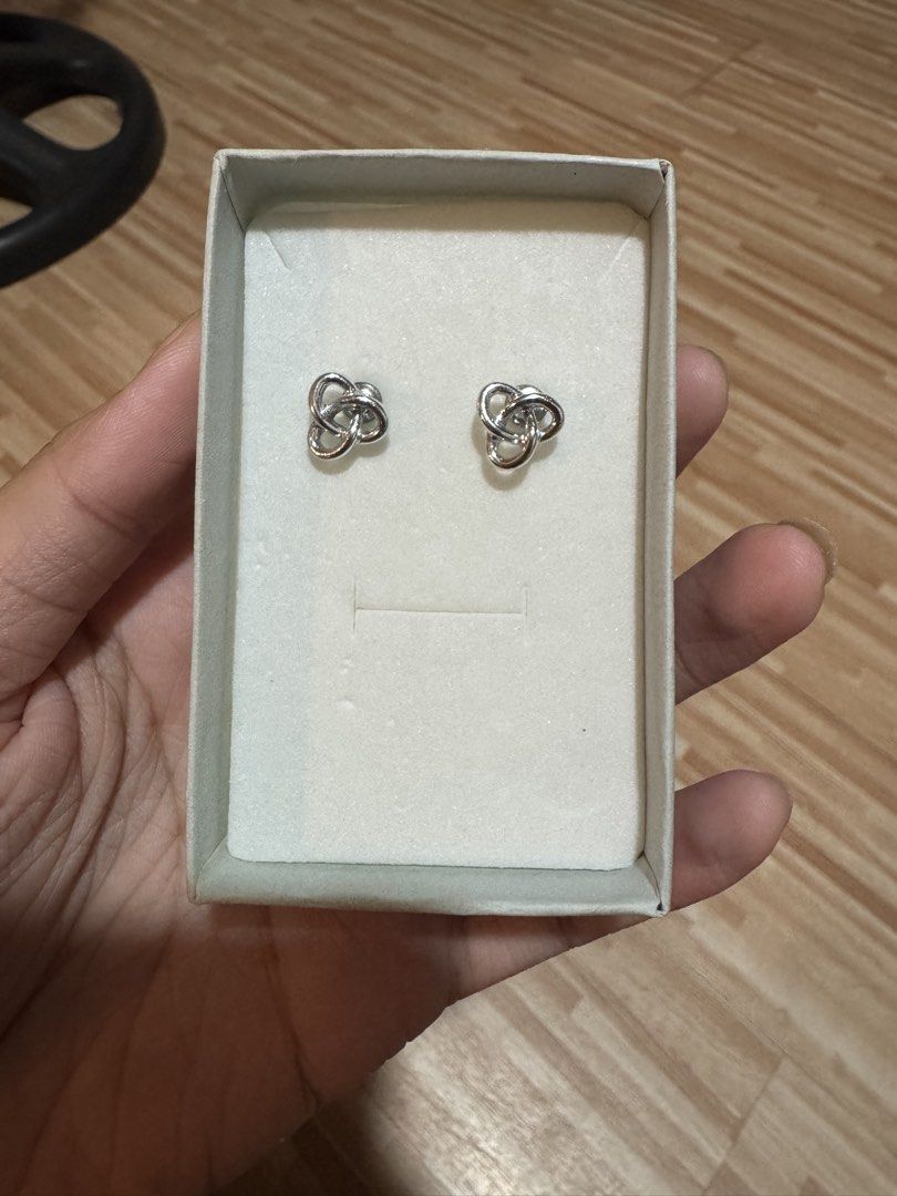 Silver knot stud earrings in floral gift box (Category: Earrings) located in Manila. Submitted by niks29 (Listing ID 1471414880, Image 1). Description: - Elegant silver-toned knot design - Comfortable stud style, perfect for everyday wear - Securely mounted on white foam backing - Includes a charming patterned decorative box tied with a grey ribbon - Great for gifting or as a treat for yourself.