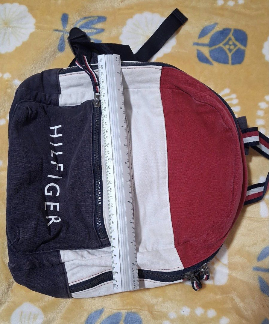 Vintage Tommy Hilfiger Colorblock Spellout Backpack (Category: Backpacks) located in Manila. Submitted by phishyyy (Listing ID 1471434479, Image 2). Description: Brand: Tommy Hilfiger Color: Navy Blue / Red / White Style: Vintage Colorblock Backpack Material: Canvas-like fabric Approx. Dimensions: 30 × 30 cm Features: * Signature TOMMY HILFIGER front lettering * Front zippered pocket * Spacious main compartment * Adjustable shoulder straps * Clas