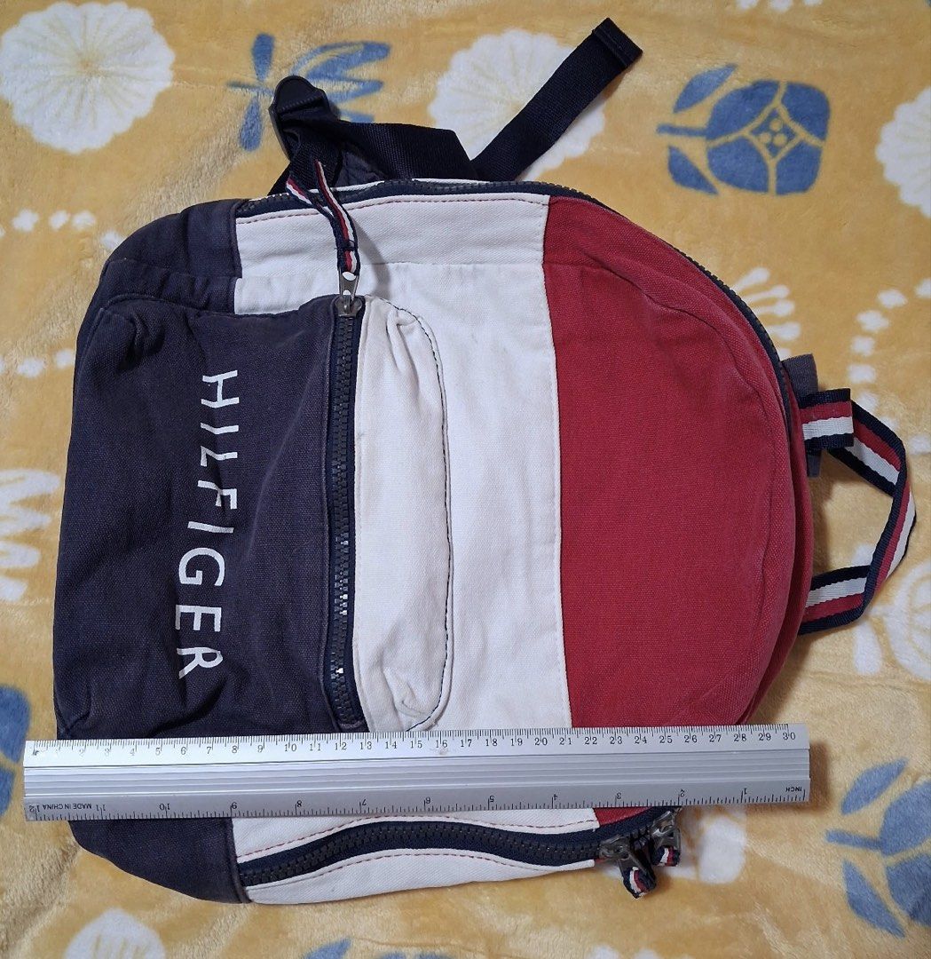 Vintage Tommy Hilfiger Colorblock Spellout Backpack (Category: Backpacks) located in Manila. Submitted by phishyyy (Listing ID 1471434479, Image 3). Description: Brand: Tommy Hilfiger Color: Navy Blue / Red / White Style: Vintage Colorblock Backpack Material: Canvas-like fabric Approx. Dimensions: 30 × 30 cm Features: * Signature TOMMY HILFIGER front lettering * Front zippered pocket * Spacious main compartment * Adjustable shoulder straps * Clas