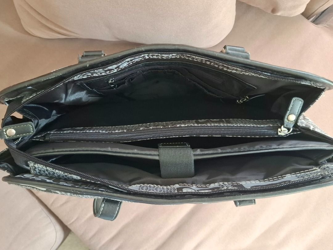 2000s Grey and black patterned laptop tote bag with compartments (Category: Tote Bags) located in Caloocan City. Submitted by zealriver-613d71 (Listing ID 1465914697, Image 3). Description: - Stylish grey and black geometric pattern with a solid black base - Sturdy top handles and 4 metal protective feet - Spacious interior with multiple compartments - Built-in padded laptop sleeve with secure strap - Convenient zippered divider pocket - Two fron