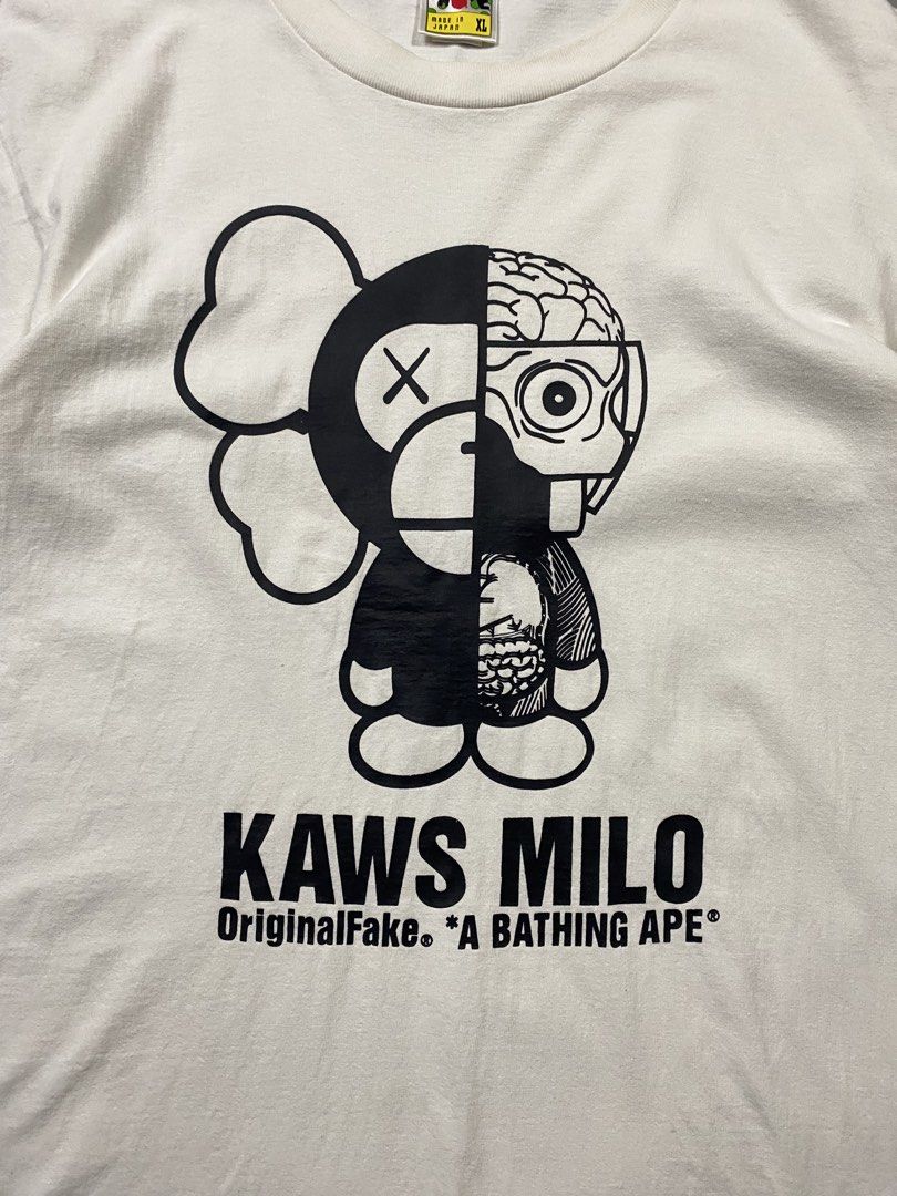 A Bathing Ape APE x KAWS Milo Tee (Category: Tshirts & Polo Shirts ) located in Santa Barbara. Submitted by thrifthub24 (Listing ID 1465771419, Image 3). Description: - Item: KAWS Milo White T-Shirt - Brand: A Bathing Ape (BAPE) - Size: XL - Material: 100% Cotton - Origin: Made in Japan - Condition: Excellent, graphic has no cracking - Details: Features iconic KAWS Milo graphic, classic neck tag, and sleeve tab branding.