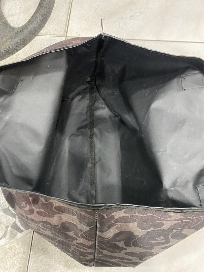 A Bathing Ape Bape Camo Tote Bag (Category: Tote Bags) located in General Trias. Submitted by mangu_ukay (Listing ID 1465952952, Image 2). Description: - Authentic BAPE black camouflage tote bag - Durable grid pattern ripstop material with black faux leather handles and trim - Roomy open-top main compartment with clean fabric lining - Signature small BAPE ape head logo tag on the side seam - Versatile and spacious everyday carryall - Condition: B