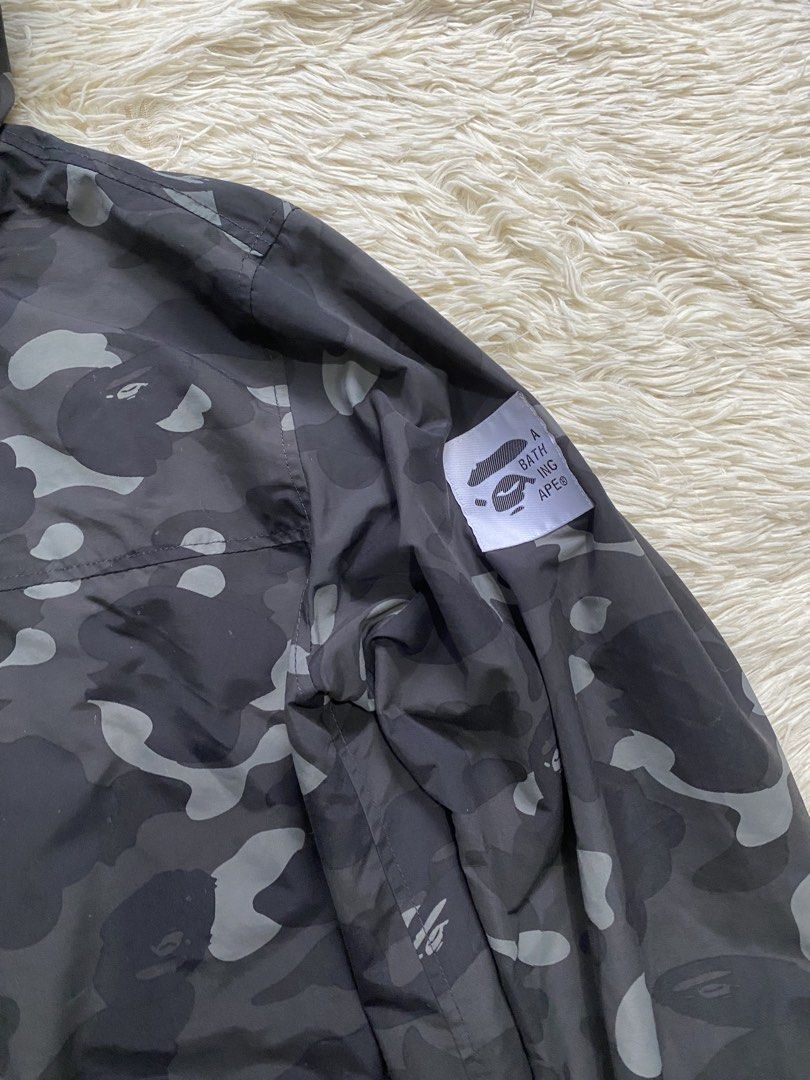 A Bathing Ape BAPE Camo Windbreaker Jacket Size L (Category: Coats, Jackets and Outerwear) located in Manila. Submitted by switchcity (Listing ID 1465898677, Image 3). Description: - Brand: BAPE (A Bathing Ape) - Item: Dark Grey Camo Windbreaker - Size: L (Tag inside collar) - Design: Large A BATHING APE text printed down the right sleeve - Features: Full zip closure, dual front pockets, drawstring hood, elastic cuffs - Materials: 100% nylon shel