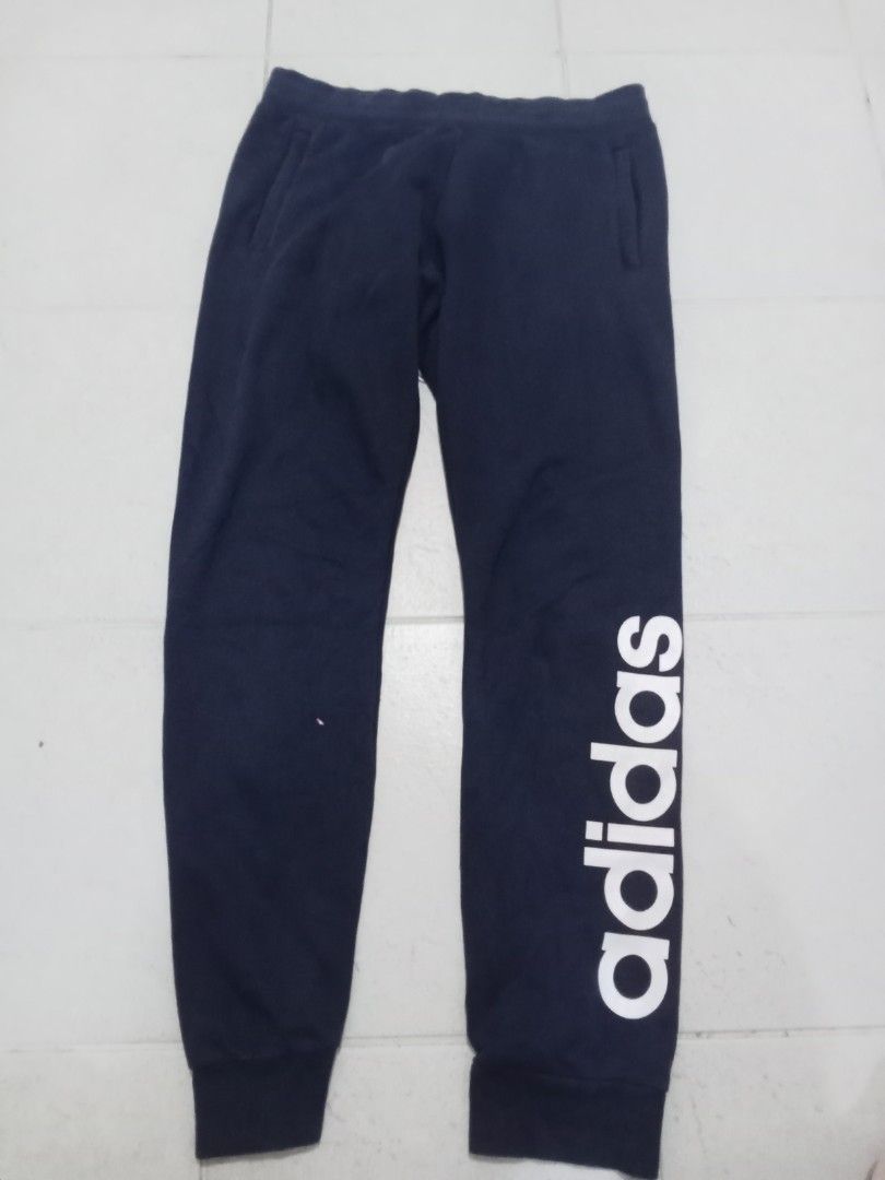 Adidas Navy Blue Joggers Sweatpants (Category: Joggers) located in Manila. Submitted by kitkathrift (Listing ID 1465867656, Image 1). Description: - Authentic navy blue Adidas sweatpants - Bold white lettering down the left leg - Adjustable elastic drawstring waistband for a custom fit - Convenient side slip pockets - Snug ribbed ankle cuffs - Perfect for workouts, gym sessions, or casual lounging.