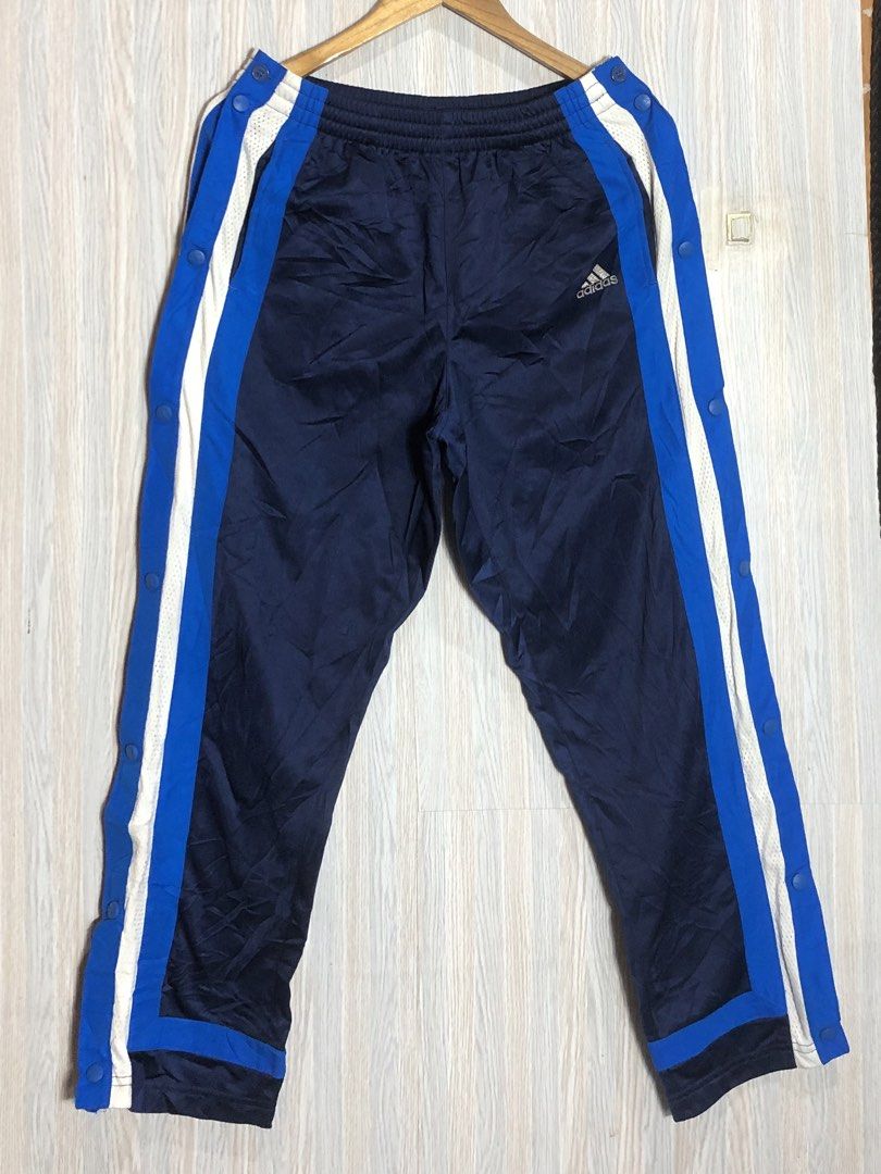 Adidas Navy Blue Snap Button Track Pants Size 32 (Category: Joggers) located in Montevista. Submitted by rdthriftshub (Listing ID 1465874178, Image 2). Description: - Brand: Adidas - Color: Navy blue with blue and white side stripes - Features: Trendy side snap buttons down the legs & embroidered logo on left thigh - Fit: Elastic waistband for all-day comfort - Size: Men's Size 32 (38-inch length) - Style: Classic retro athletic look.