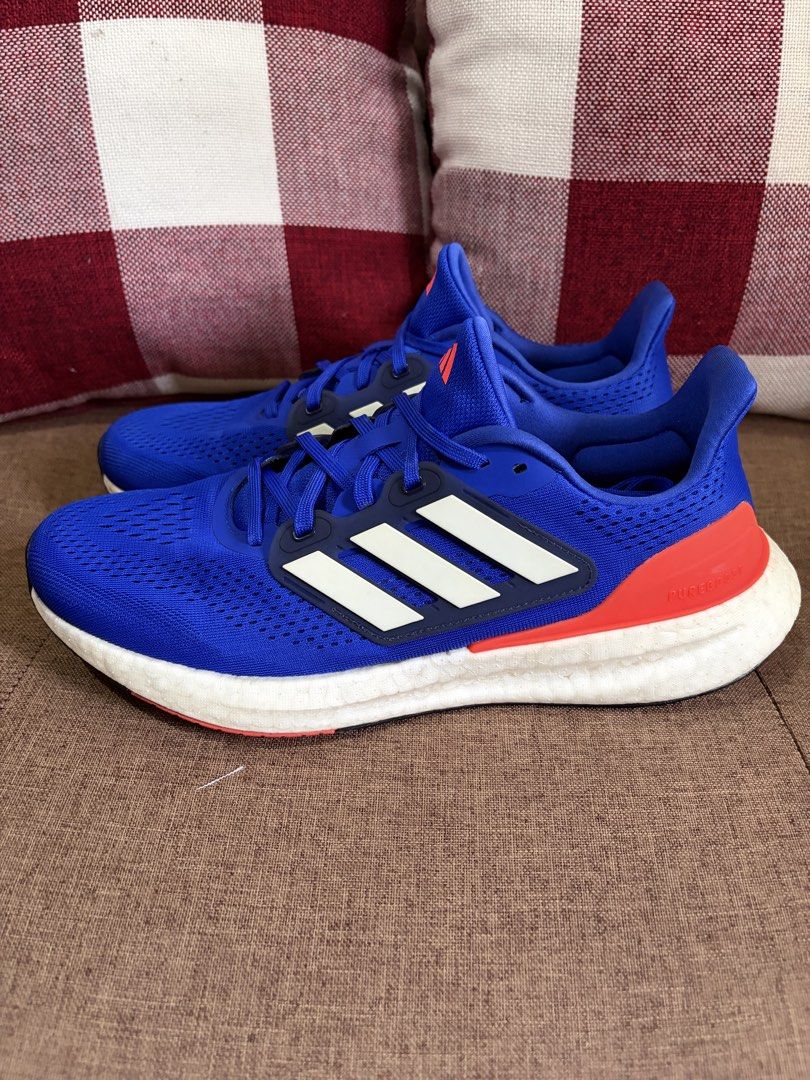 [Used] Adidas Pureboost 23 (US10/UK9.5/28cm) (Category: Sneakers) located in Quezon City. Submitted by smosh_67 (Listing ID 1465801112, Image 2). Description: - Brand: Adidas - Color: Bright blue with red-orange heel counters and white stripes - Sole: White Boost midsole with durable rubber outsole - Upper: Lightweight mesh with toe box ventilation - Closure: Regular lace-up - Condition: Clean overall with minor wear on the soles (8.5/10) -Box: N