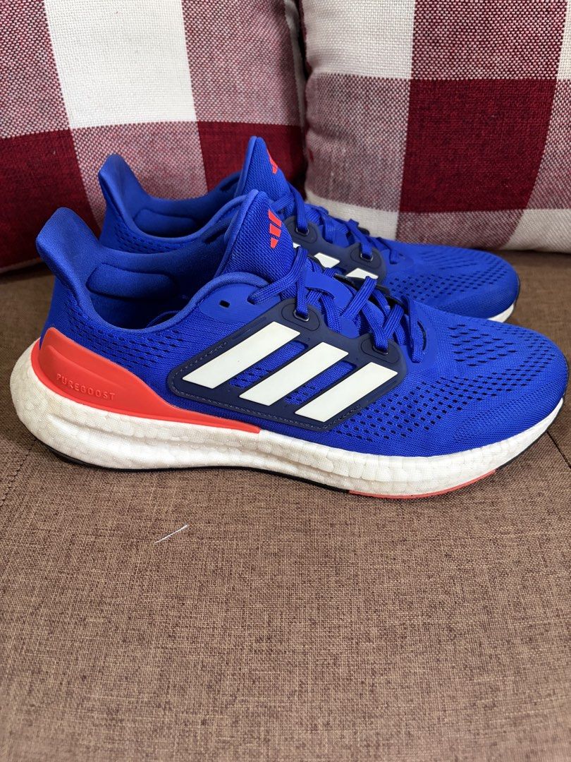 [Used] Adidas Pureboost 23 (US10/UK9.5/28cm) (Category: Sneakers) located in Quezon City. Submitted by smosh_67 (Listing ID 1465801112, Image 3). Description: - Brand: Adidas - Color: Bright blue with red-orange heel counters and white stripes - Sole: White Boost midsole with durable rubber outsole - Upper: Lightweight mesh with toe box ventilation - Closure: Regular lace-up - Condition: Clean overall with minor wear on the soles (8.5/10) -Box: N