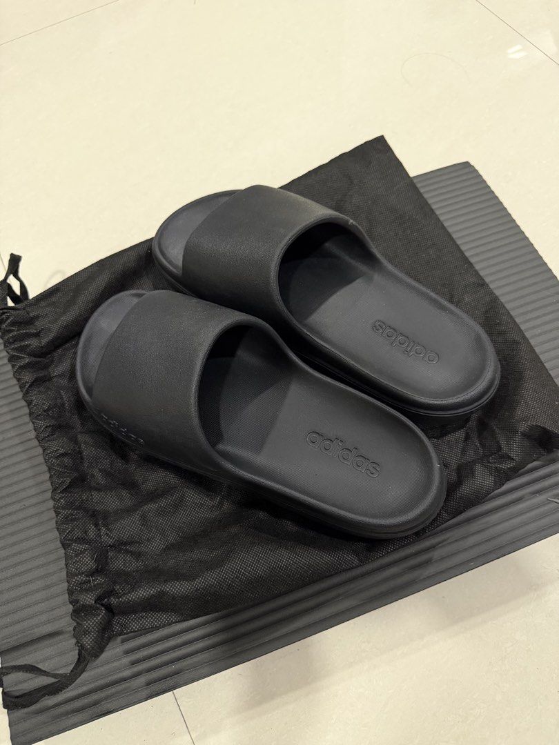 Adidas Slides Black Sandals (Category: Slippers & Slides) located in Manila. Submitted by imprincessg888 (Listing ID 1465863151, Image 1). Description: - Brand: Adidas - Color: All Black - Condition: Great, with very minimal wear on the soles - Design: Clean slip-on style with textured footbed and side branding - Inclusions: Comes with a black dust bag - Ideal for: Everyday casual use, running errands, or lounging at home.