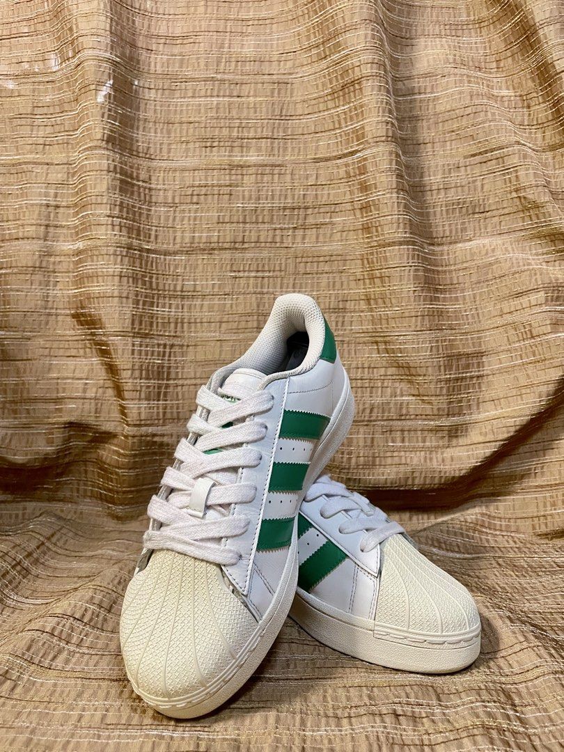 Adidas Superstar Green XLG (Category: Sneakers) located in Manila. Submitted by phil.fabulous (Listing ID 1465847939, Image 2). Description: - Brand/Model: Adidas Superstar Platform - Colorway: White with Green stripes and heel tab - Design: Classic shell toe, thick platform sole, and iconic gold 'SUPERSTAR' lettering - Condition: Clean overall, with minimal signs of wear on uppers and soles - Inclusions: Comes with original white laces - Style: 