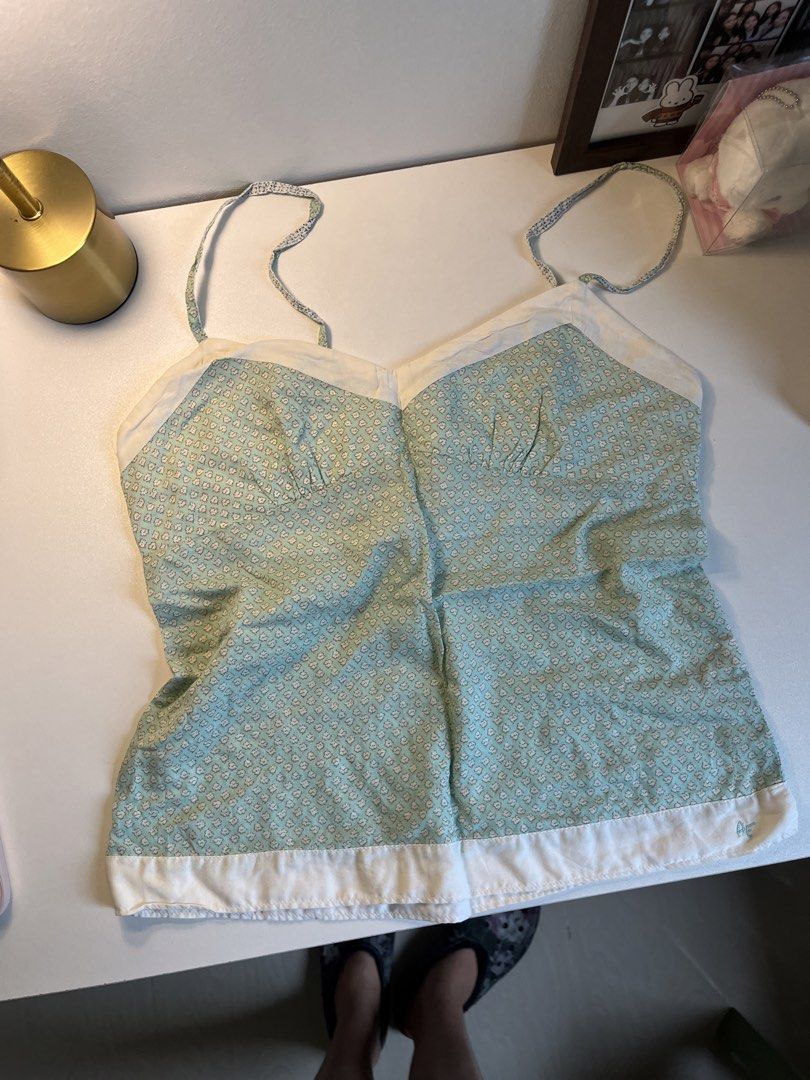 American Eagle Green Floral Print Cami Top (Category: Sleeveless) located in Bacolod City. Submitted by miffywhitematcha (Listing ID 1465912220, Image 1). Description: - Style: Green and white floral print camisole - Details: Sweetheart neckline, white contrast trim, and a small blue embroidered logo near the hem - Straps: Thin spaghetti straps - Material: Lightweight and breathable fabric - Fit & Pairing: Great for warm weather, easy to style wi