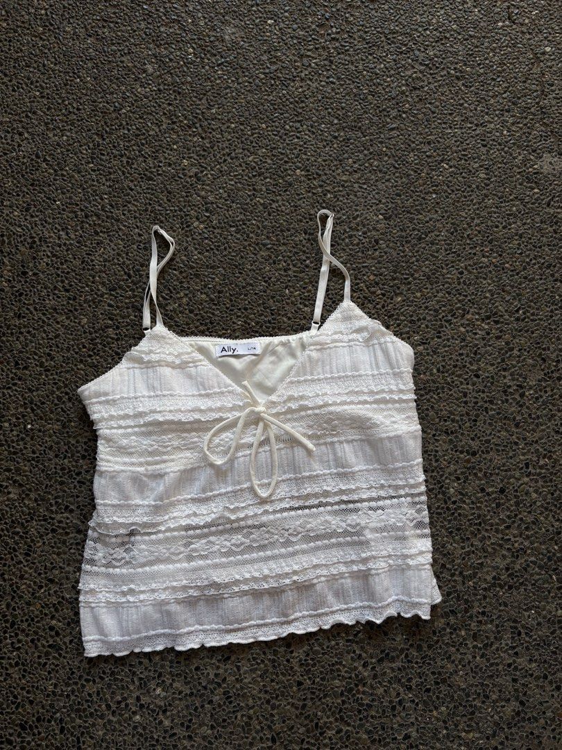 Ally White Lace Cami Top Size L/14 (Category: Sleeveless) located in San Fernando. Submitted by gigikyla (Listing ID 1465921138, Image 1). Description: - Brand: Ally - Size: L / 14 - Color: White - V-neckline with center tie string detail - Adjustable thin straps - Textured fabric with horizontal sheer lace panels - Scalloped hem - Ideal for warm weather and summer styling.