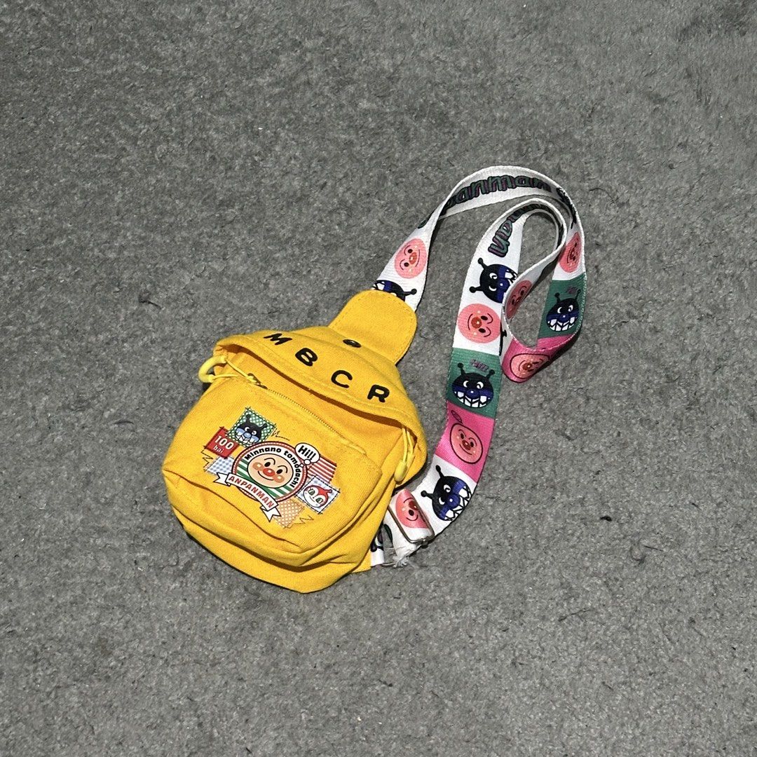 Anpanman Yellow Sling Bag with Character Strap (Category: Cross-body Bags) located in Lipa City. Submitted by jecoparra (Listing ID 1465917833, Image 2). Description: - Vibrant yellow canvas sling bag featuring Anpanman patches and bold MBCR lettering - Adjustable strap with colorful Anpanman and Baikinman graphics - Secure zippered main compartment for your small essentials - Compact and lightweight design, perfect for crossbody or shoulder wear
