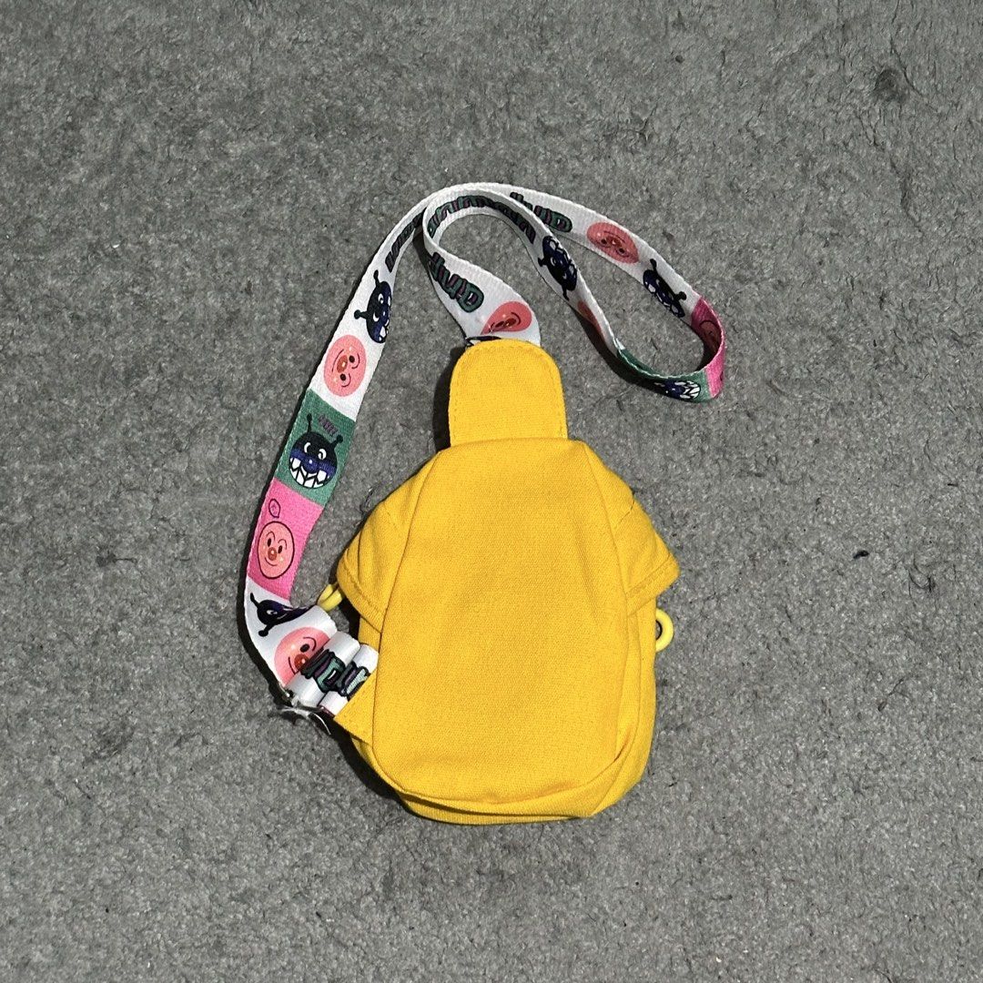 Anpanman Yellow Sling Bag with Character Strap (Category: Cross-body Bags) located in Lipa City. Submitted by jecoparra (Listing ID 1465917833, Image 3). Description: - Vibrant yellow canvas sling bag featuring Anpanman patches and bold MBCR lettering - Adjustable strap with colorful Anpanman and Baikinman graphics - Secure zippered main compartment for your small essentials - Compact and lightweight design, perfect for crossbody or shoulder wear