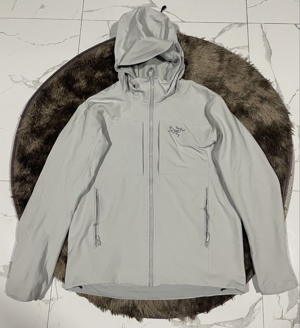 Arc'teryx Softshell Hooded Jacket Grey Size M (Category: Coats, Jackets and Outerwear) located in Calapan. Submitted by lucasthrifts (Listing ID 1465921024, Image 1). Description: - Brand: Arc'teryx - Color: Light Grey - Style: Softshell jacket with attached drawcord hood and full zip front - Pockets: Two zippered chest pockets and two hand pockets - Interior: Comfortable mesh lining - Measurements: Pit to pit approx. 21 inches, Length approx. 27