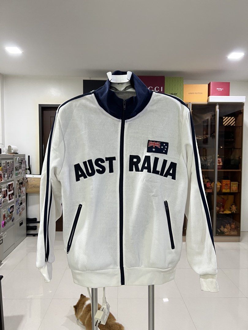 Australia Track Jacket White Navy Blue Full Zip (Category: Coats, Jackets and Outerwear) located in Manila. Submitted by imprincessg888 (Listing ID 1465852007, Image 1). Description: - Color: White with navy blue contrast accents - Design: Australian flag patch and bold 'Australia' text on the chest - Details: Striped detailing on sleeves, ribbed collar, cuffs, and hem - Pockets: Convenient zipped side pockets with a full front zipper - Condition