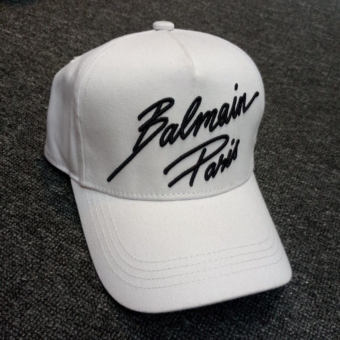 Balmain Paris White Baseball Cap (Category: Caps & Hats) located in Manila. Submitted by pablopresk0. (Listing ID 1465833924, Image 2). Description: - Brand: Balmain Paris - Color: Clean White with Black cursive embroidery - Fit: Structured crown, curved brim, and adjustable metal strap with brand lettering - Details: Interior taping with repeated Balmain logos - Style: Perfect for daily wear and street fits - Shipping: Same day delivery within M
