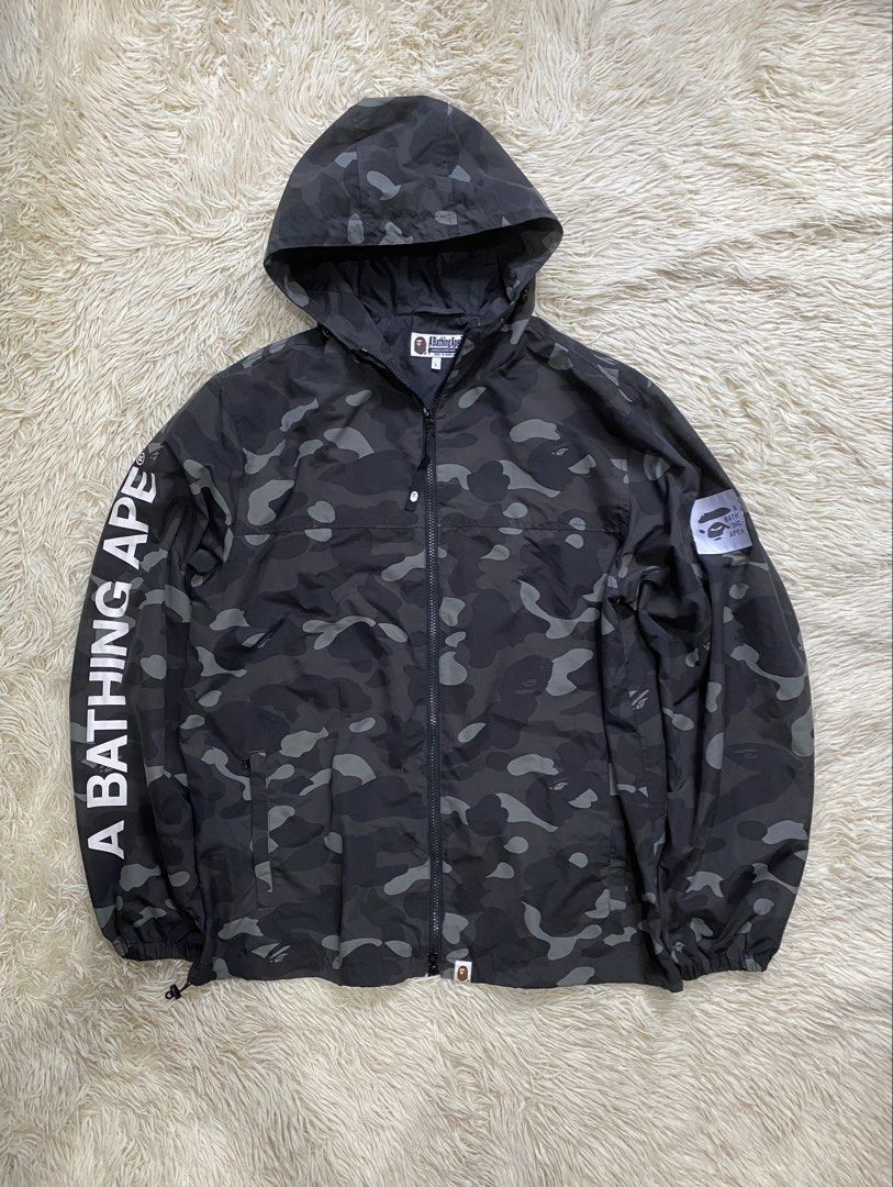 BAPE ABC Camo Windbreaker Jacket Size L (Category: Coats, Jackets and Outerwear) located in Antipolo. Submitted by switchneighborhood (Listing ID 1465795460, Image 1). Description: - Brand: A Bathing Ape (BAPE) - Design: Black & grey camo pattern with bold sleeve text - Size: Large - Material: 100% nylon shell - Features: Full zip-up front, adjustable drawstring hood, and two side zipper pockets - Condition: Great streetwear layer for cooler weat