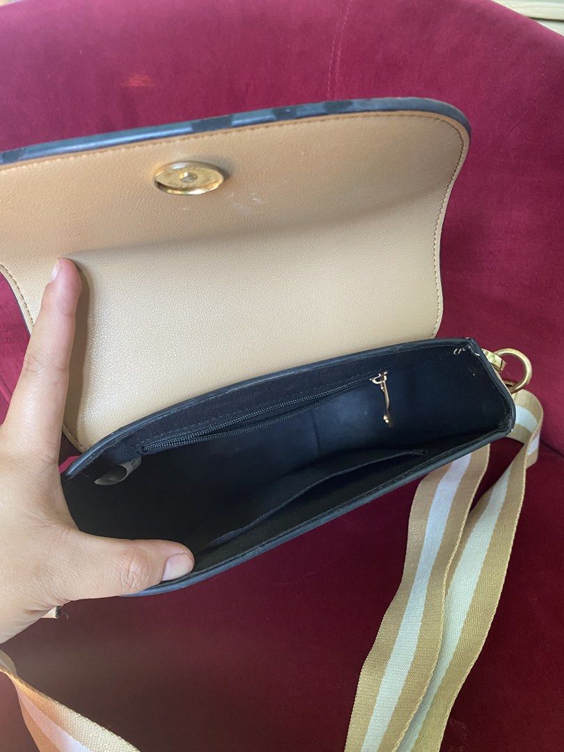 Beige Saddle Crossbody Bag with Striped Strap (Category: Cross-body Bags) located in La Trinidad. Submitted by kinleyky (Listing ID 1465766896, Image 3). Description: - Color: Versatile neutral beige with smooth faux leather finish - Strap: Thick, adjustable white and tan striped pattern - Hardware: Elegant gold-tone accents - Closure: Secure front flap with magnetic snap - Interior: Main compartment, 1 zippered pocket, and 1 open slip pocket - S