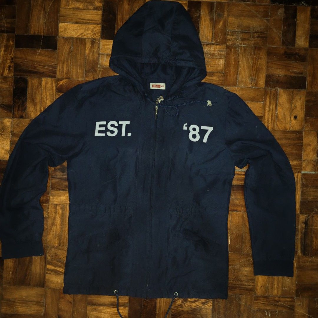 Bench Navy Blue Hooded Jacket Size XXL (Category: Coats, Jackets and Outerwear) located in Manila. Submitted by ekko_0xx (Listing ID 1465885228, Image 1). Description: - Brand: Bench - Color: Dark blue - Size: XXL - Design: Full zip front, adjustable hood and hem drawstrings, large 'EST. 87' white chest lettering - Pockets: Two front pockets with button flaps - Condition/Style: Casual outerwear, great for everyday wear or layering.